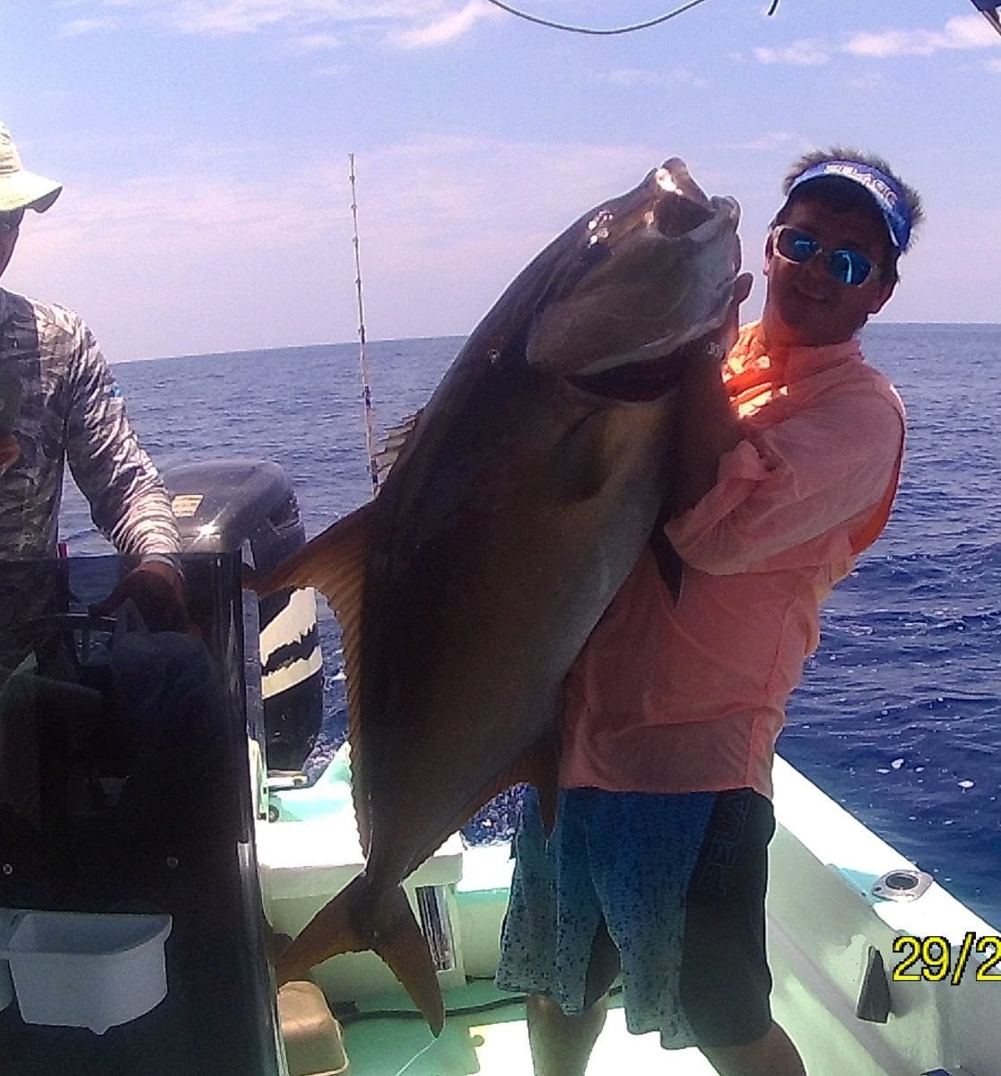Angler holding a large greater amberjack on a fishing trip near Caño Island, Costa Rica