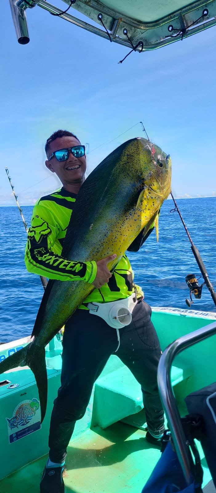 Angler holding a large mahi-mahi during a fishing tour in Sierpe, Costa Rica