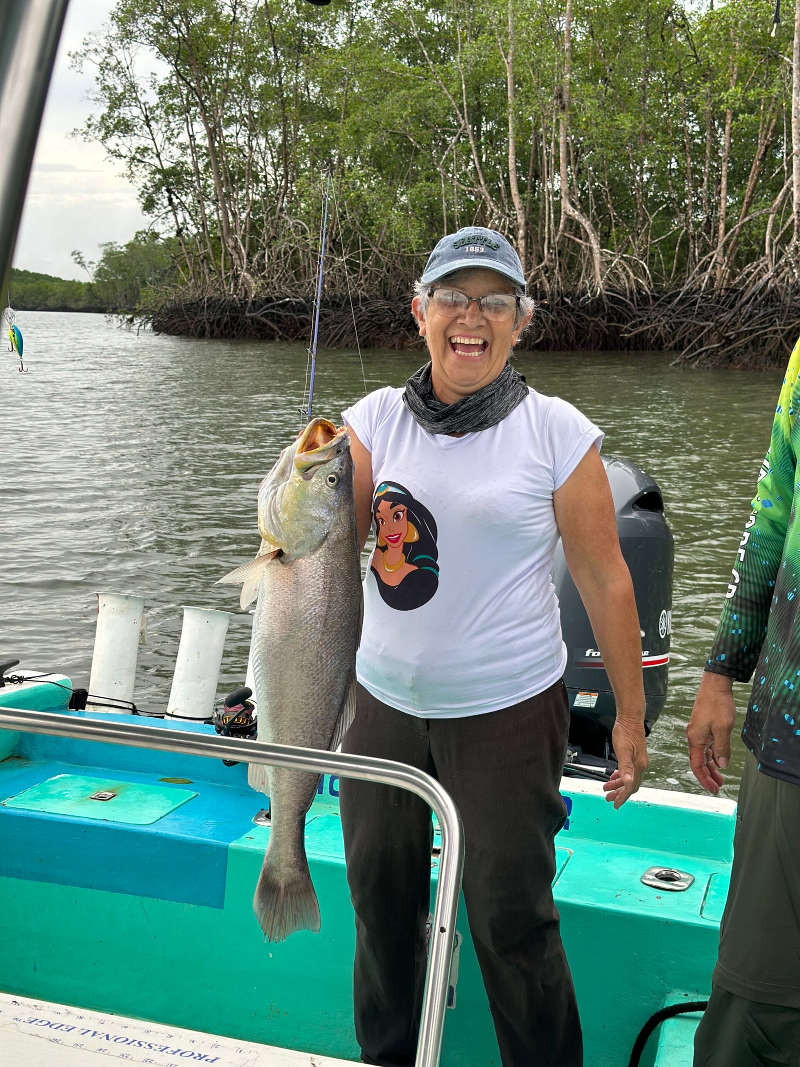 Woman holding a large corvina on a fishing boat in the Sierpe River, Costa Rica