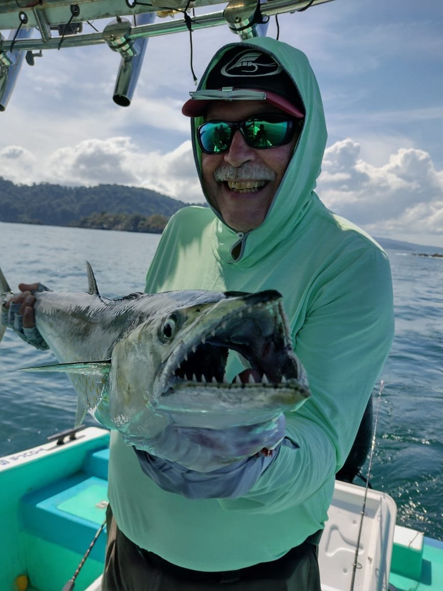 Angler holding a large Spanish mackerel during a fishing tour in Sierpe, Costa Rica.