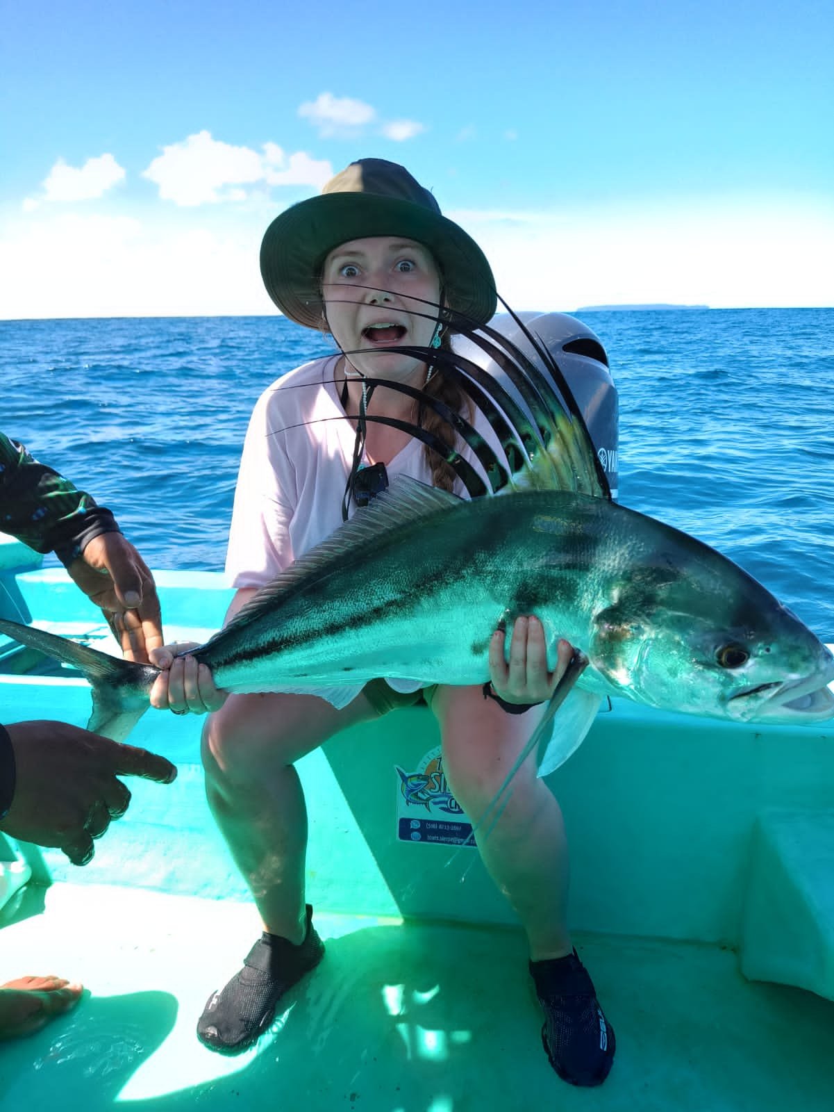 Young girl holding a large roosterfish on a fishing boat in Costa Rica